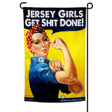 A garden flag featuring a graphic of a woman with a speech bubble saying 'Jersey Girls Get Shit Done!' against a yellow background.